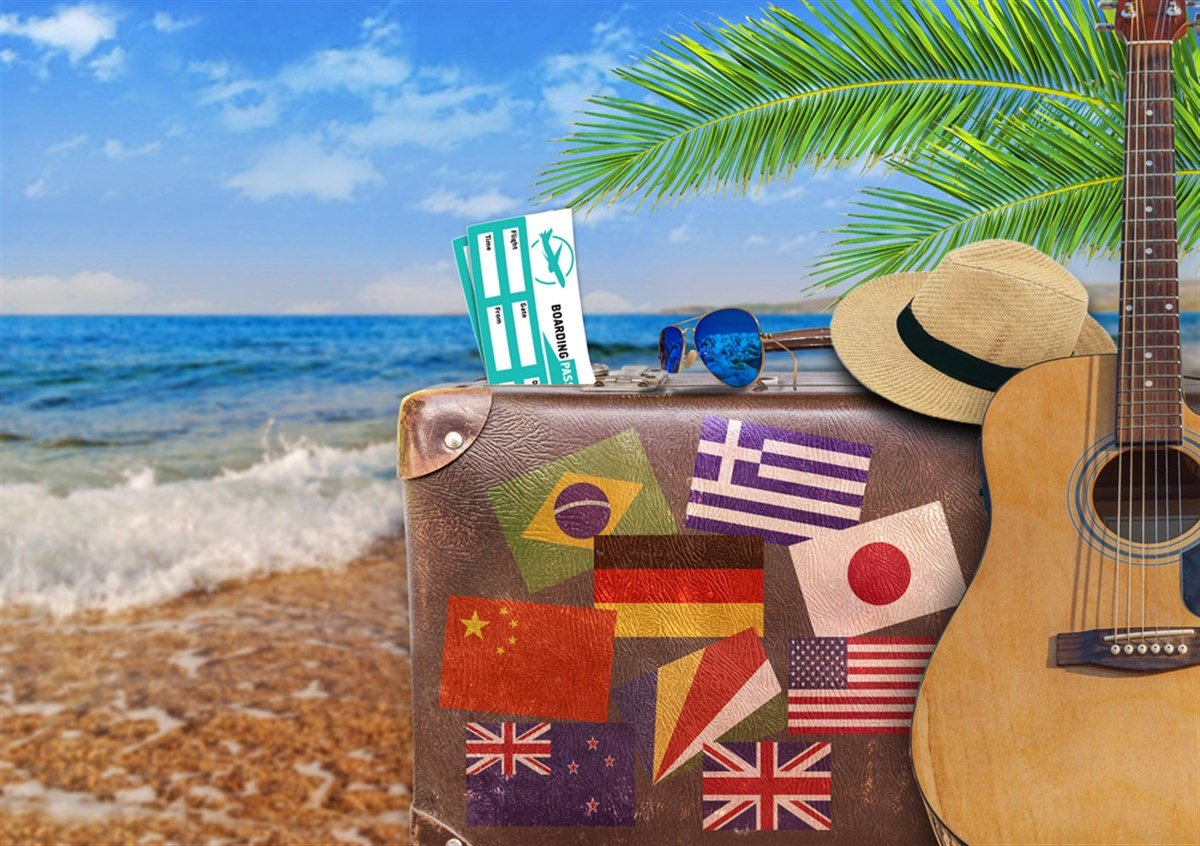 Concept of summer traveling with old suitcase and guitar - stock image