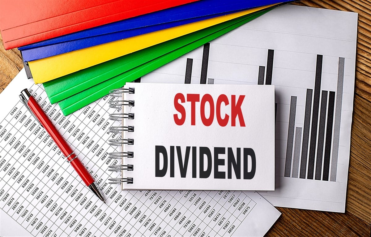 Stock Dividend text on a notebook with folder on chart.