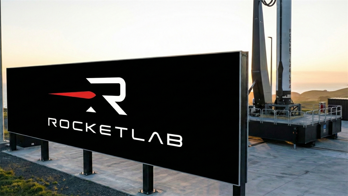 Rocket Lab logo billboard beside a rocket on a coastal launchpad at sunrise, highlighting the space tech boom.