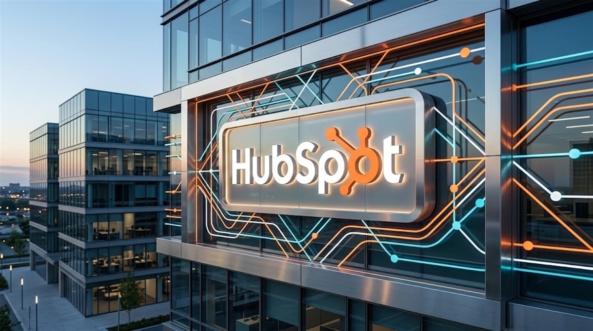 HubSpot logo displayed on the exterior of a modern glass office building at dusk.