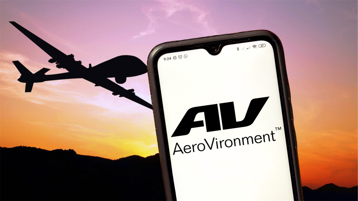 Smartphone displaying the AeroVironment logo in the foreground, with a silhouette of a military drone in the background.
