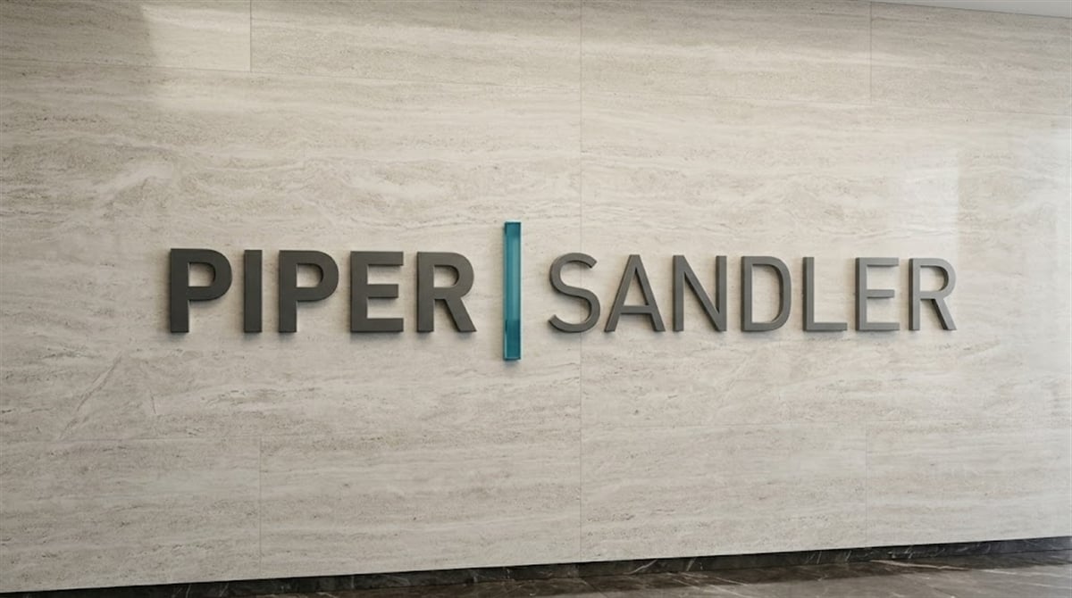 Piper Sandler logo mounted on a marble wall inside a corporate office.