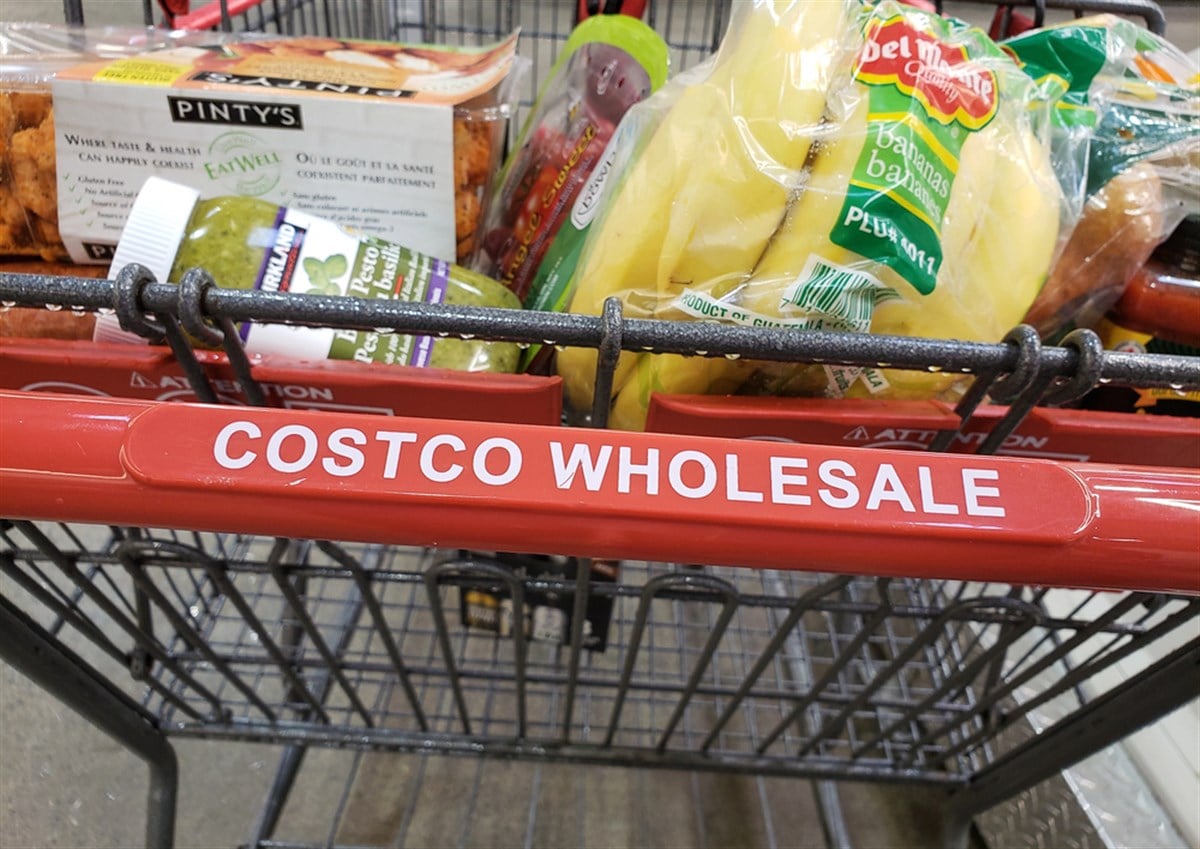 Grocery cart with Costco Wholesale label full of groceries.
