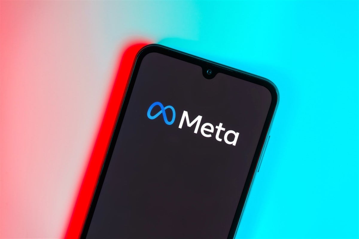 Prague, Czechia: Modern smartphone device on blue surface background with meta logo. - Stock Editorial Photography