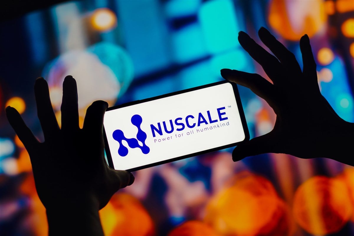 Hands hold a phone displaying NuScale Power’s logo as the company’s strategic AI-energy investments draw investor interest.