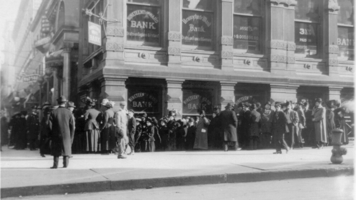 Hundreds of people line up in front of a bank.