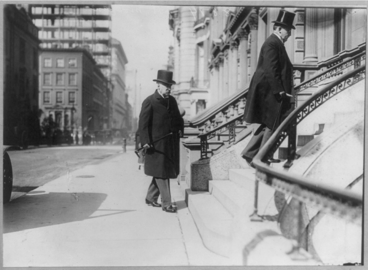 Two bankers walking up the stairs in front of a building.