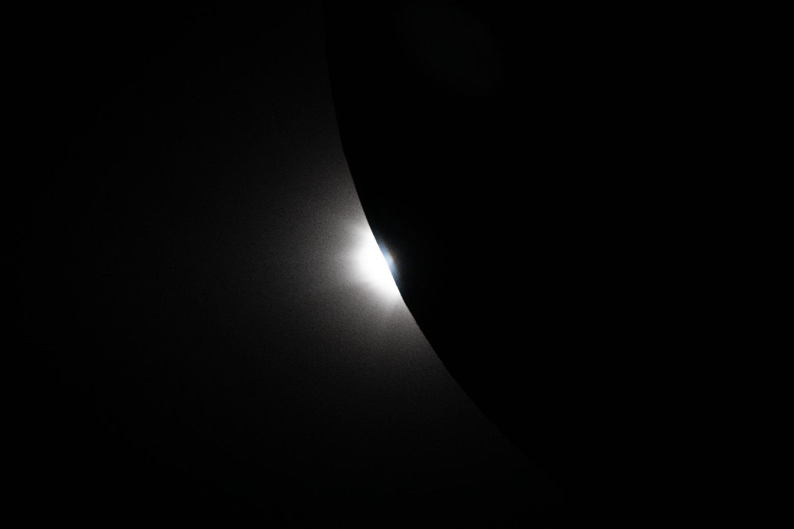 In this image provided by NASA, the Artemis II crew captured this image of the Sun beginning to peek out from behind the Moon as an eclipse transitions out of totality during a lunar flyby, Monday, April 6, 2026. (NASA via AP)