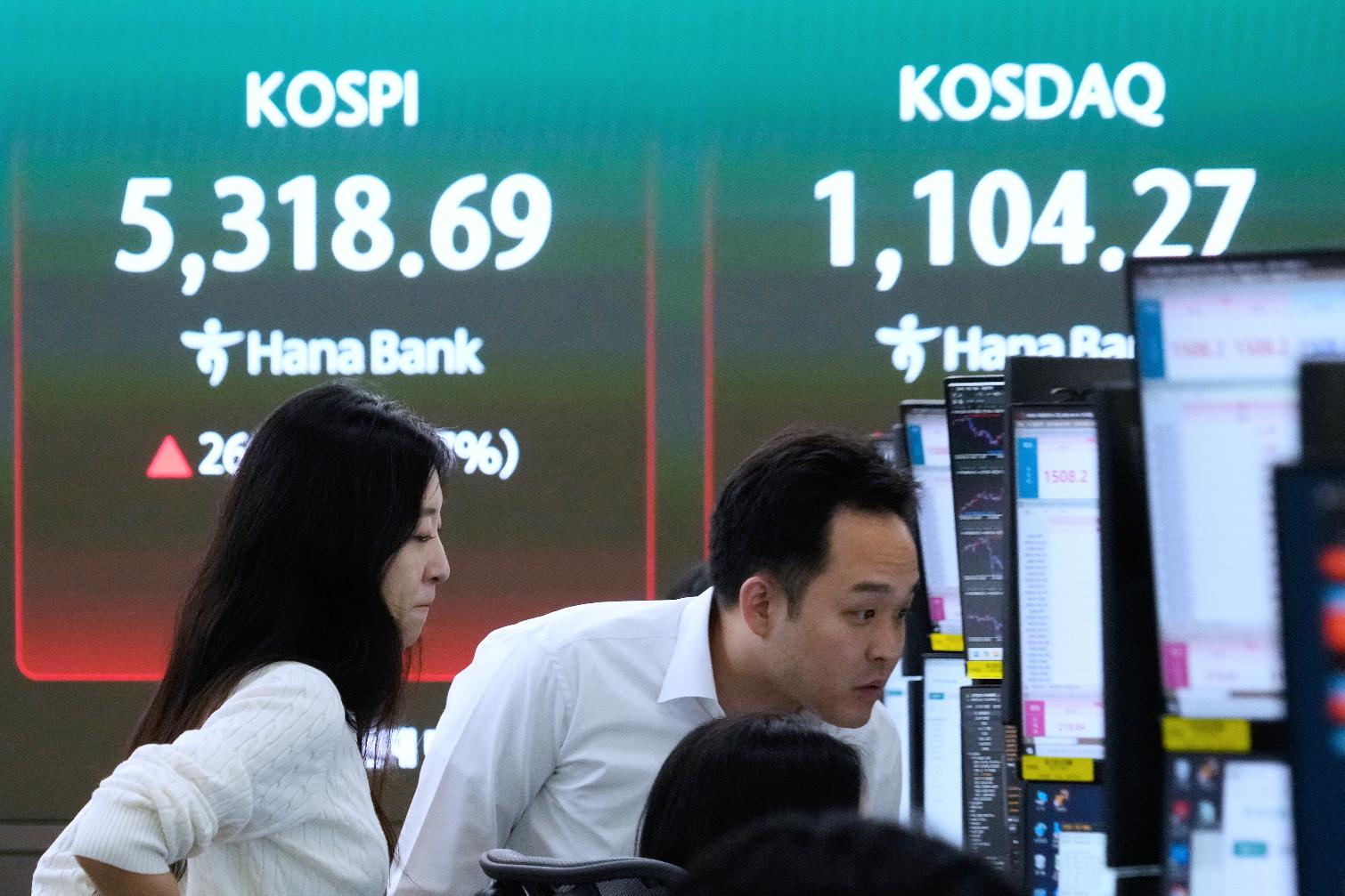 Currency traders watch monitors near a screen showing the Korea Composite Stock Price Index (KOSPI), left, at the foreign exchange dealing room of the Hana Bank headquarters in Seoul, South Korea, Wednesday, April 1, 2026. (AP Photo/Ahn Young-joon)