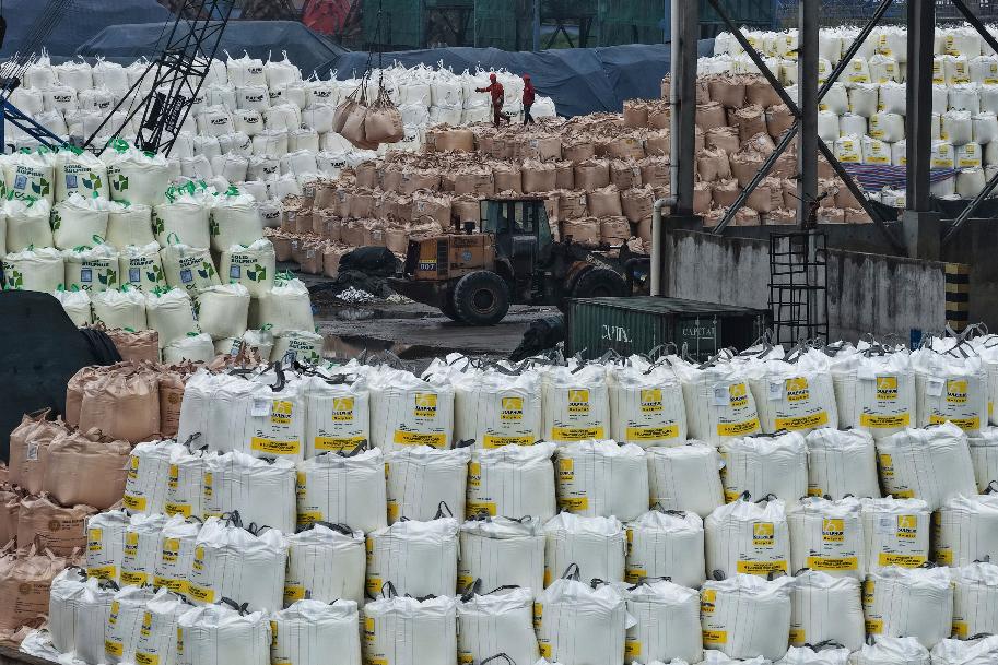 Workers transfer bags of imported solid sulfur in a port in Nanjing in eastern China's Jiangsu province, Tuesday, April 14, 2026. (Chinatopix Via AP) CHINA OUT