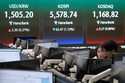 Currency traders watch monitors near a screen showing the Korea Composite Stock Price Index (KOSPI), top center, and the foreign exchange rate between U.S. dollar and South Korean won, top left, at the foreign exchange dealing room of the Hana Bank headquarters in Seoul, South Korea, Thursday, March 26, 2026. (AP Photo/Ahn Young-joon)
