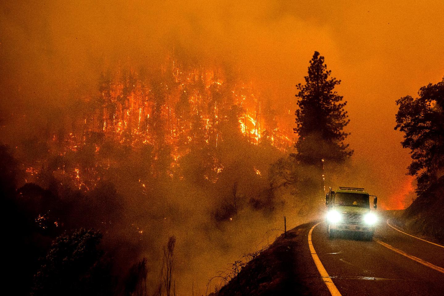 FILE - A firetruck drives along California Highway 96 as the McKinney Fire burns in Klamath National Forest, Calif., on July 30, 2022. (AP Photo/Noah Berger, File)