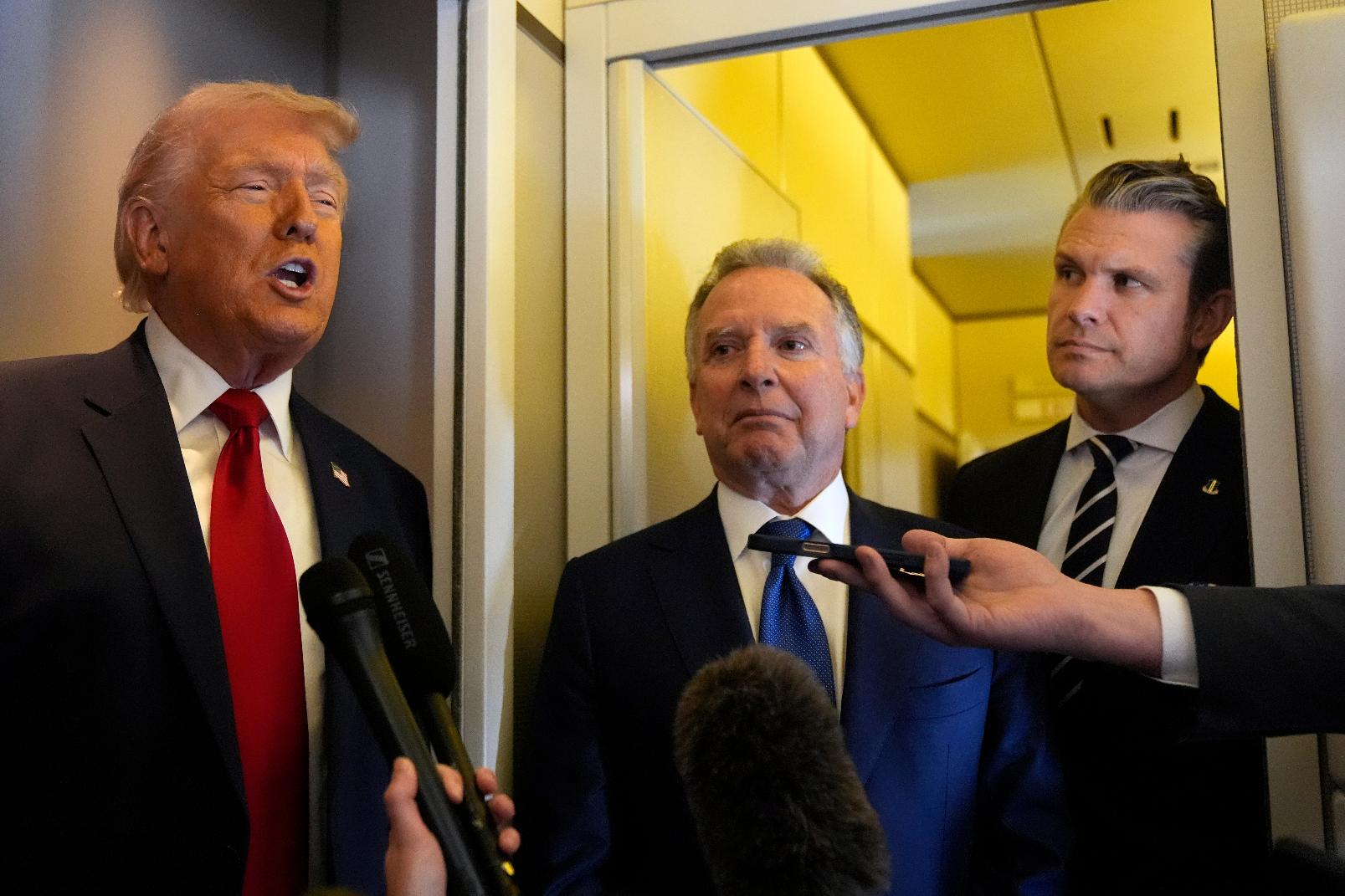 President Donald Trump speaks to reporters as White House Special Envoy to the Middle East Steve Witkoff, center, and Defense Secretary Pete Hegseth listen while traveling aboard Air Force One en route from Dover Air Force Base, Del., to Miami, Saturday, March 7, 2026. (AP Photo/Mark Schiefelbein)