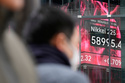 People walk near an electronic stock board showing Japan's Nikkei index at a securities firm Thursday, Feb. 26, 2026, in Tokyo. (AP Photo/Eugene Hoshiko)