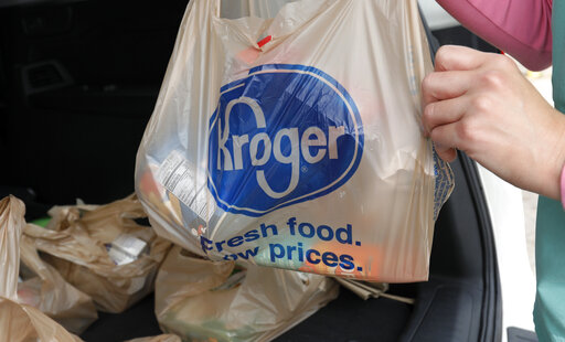FILE - A customer removes her purchases at a Kroger grocery store in Flowood, Miss., Wednesday, June 26, 2019.  Two of the nation’s largest grocers have agreed to merge in a deal that would help them better compete with Walmart, Amazon and other major companies that have stepped into the grocery business. Kroger on Friday, Oct. 14, 2022  bid $20 billion for Albertsons Companies Inc., or $34.10 per share.(AP Photo/Rogelio V. Solis, File)