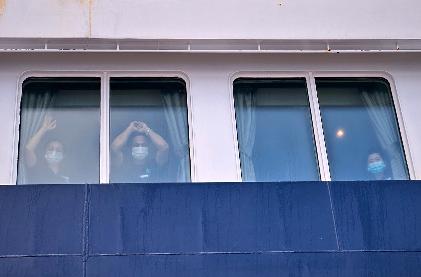 Passengers watch as others are disembarked from the hantavirus-stricken cruise ship MV Hondius at the port of Granadilla in Tenerife, Canary Islands, Spain, Sunday, May 10, 2026. (AP Photo)