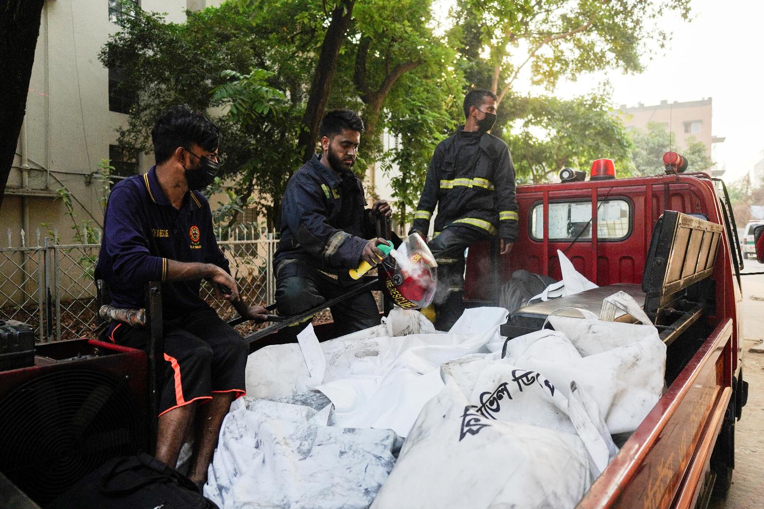 Firefighters transport the bodies of victims who lost their lives in a fire at a gas-lighter manufacturing factory in Keraniganj on the outskirts of Dhaka, Bangladesh, Saturday, April 4, 2026. (AP Photo/MD. Samsul Islam Hady)