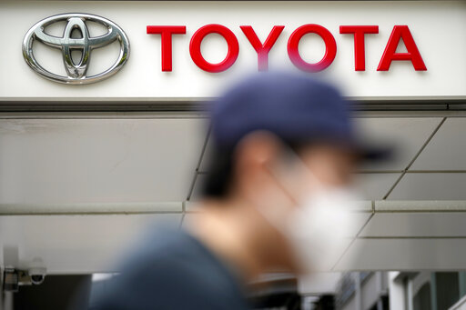 A man walks past a Toyota dealer in Tokyo on May 11, 2022. Toyota Motor Corp. reported Thursday, Aug. 4, 2022 a quarterly profit of 736.8 billion yen ($5.5 billion), down from 897.8 billion yen the previous year. (AP Photo/Eugene Hoshiko)
