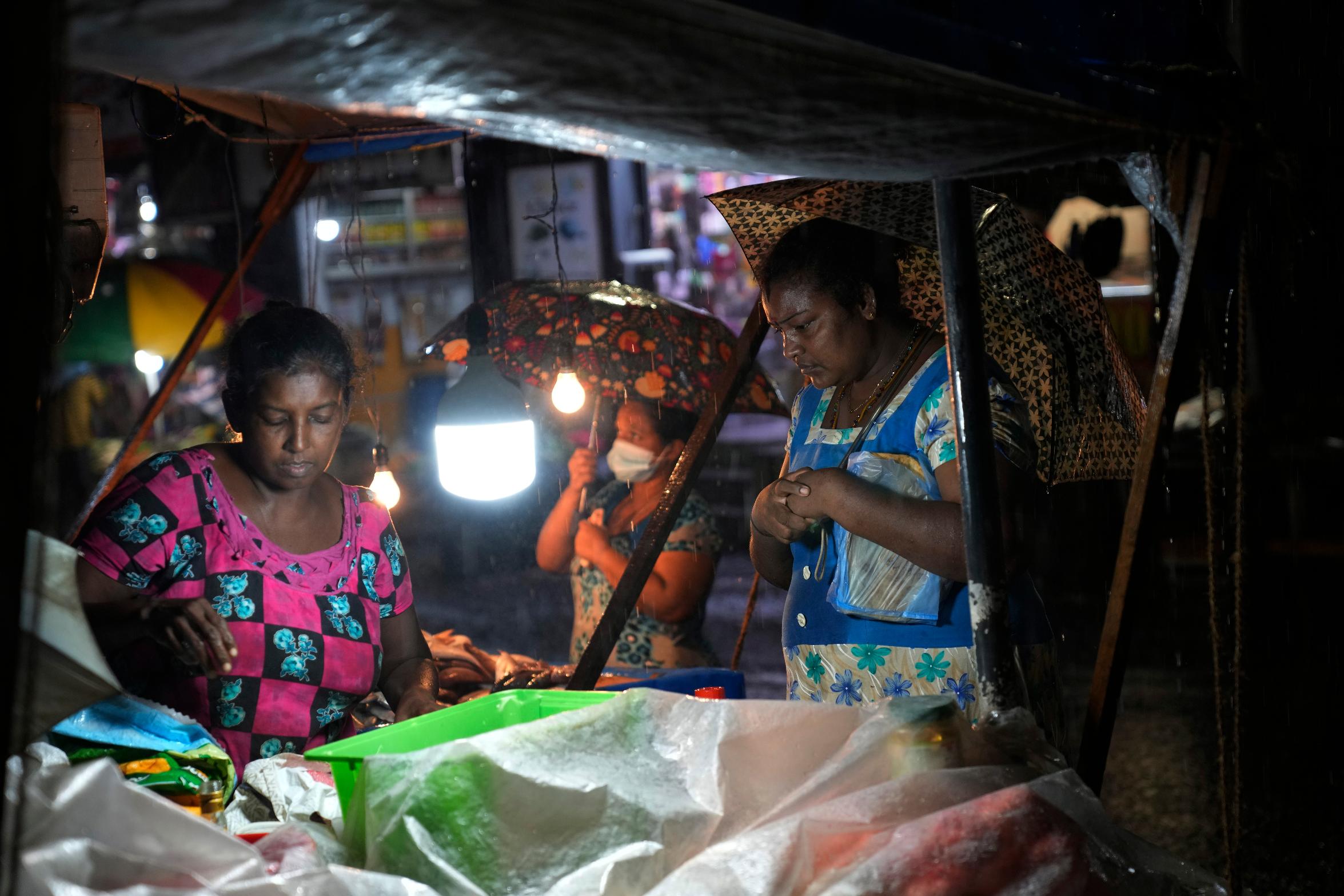 Women buy food from a roadside stall in Colombo, Sri Lanka, Friday, Dec. 8, 2023. The Asian Development Bank said Friday that it has approved $200-million concessional loan to debt-stricken Sri Lanka to help stabilize the country’s finance sector following an unprecedented economic crisis that engulfed the Indian Ocean island nation last year. (AP Photo/Eranga Jayawardena)