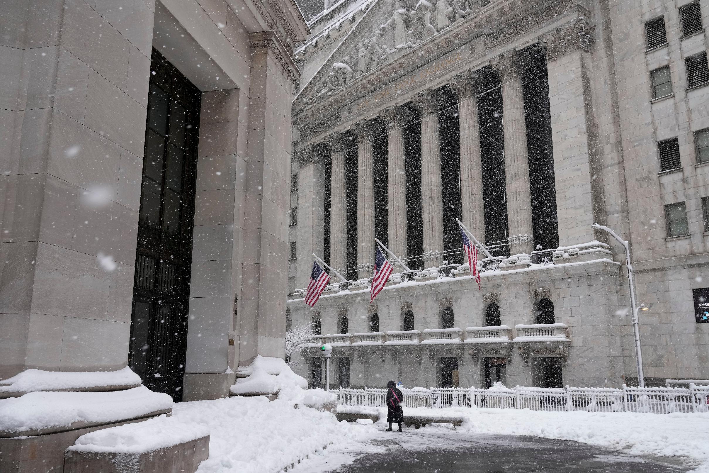 A pedestrian walks outside the New York Stock Exchange during a snow storm, Monday, Feb. 23, 2026, in New York. (AP Photo/Seth Wenig)