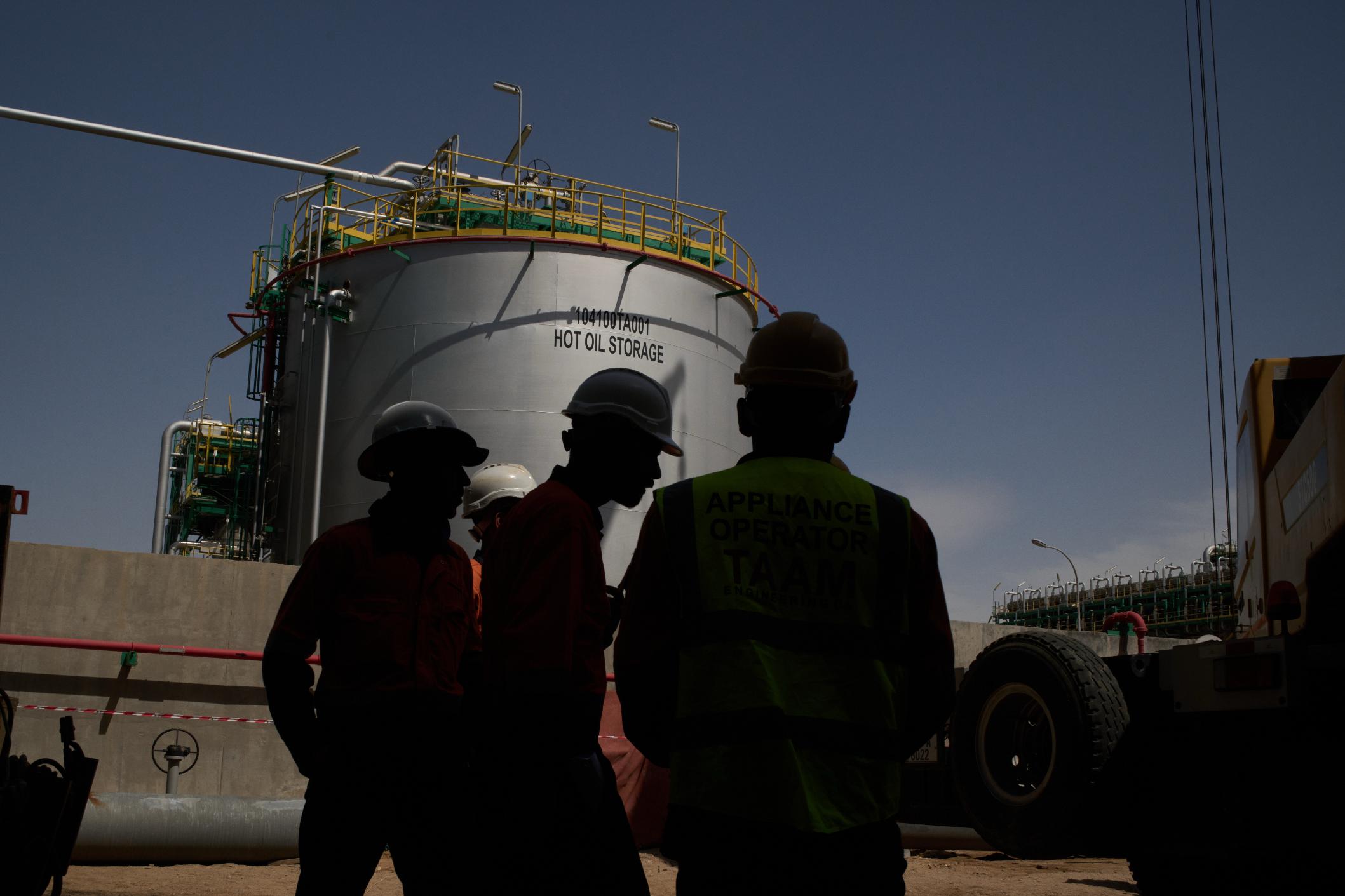 Workers stand in an area at a degassing station in Zubair oil field, whose operations have being reduced due to the Mideast war triggered by the U.S. and Israeli attacks on Iran, near Basra, Iraq, Saturday, March 28, 2026. (AP Photo/Leo Correa)