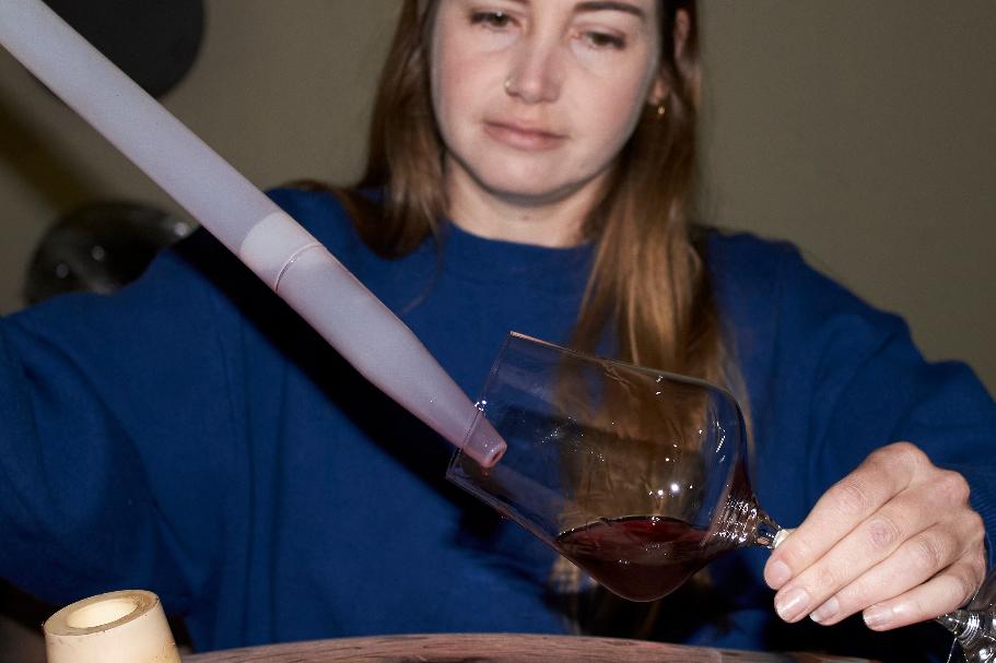 Natasha Jacka pours wine from an oak barrel into a glass using a "wine thief" in Cape Town, South Africa, Thursday, June 4, 2026. (AP Photo/Neil Shaw)