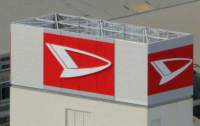 This aerial photo shows the logo of Daihatsu Motor at its headquarters in Ikeda, Osaka, Wednesday, Dec. 20, 2023. Toyota Motor Corp. said it's subsidiary Daihatsu will suspend shipments of all of its vehicles in and outside of Japan in a safety data fabrication scandal after an investigation found issues with 64 models that included Toyota and other brands. (Kyodo News via AP)