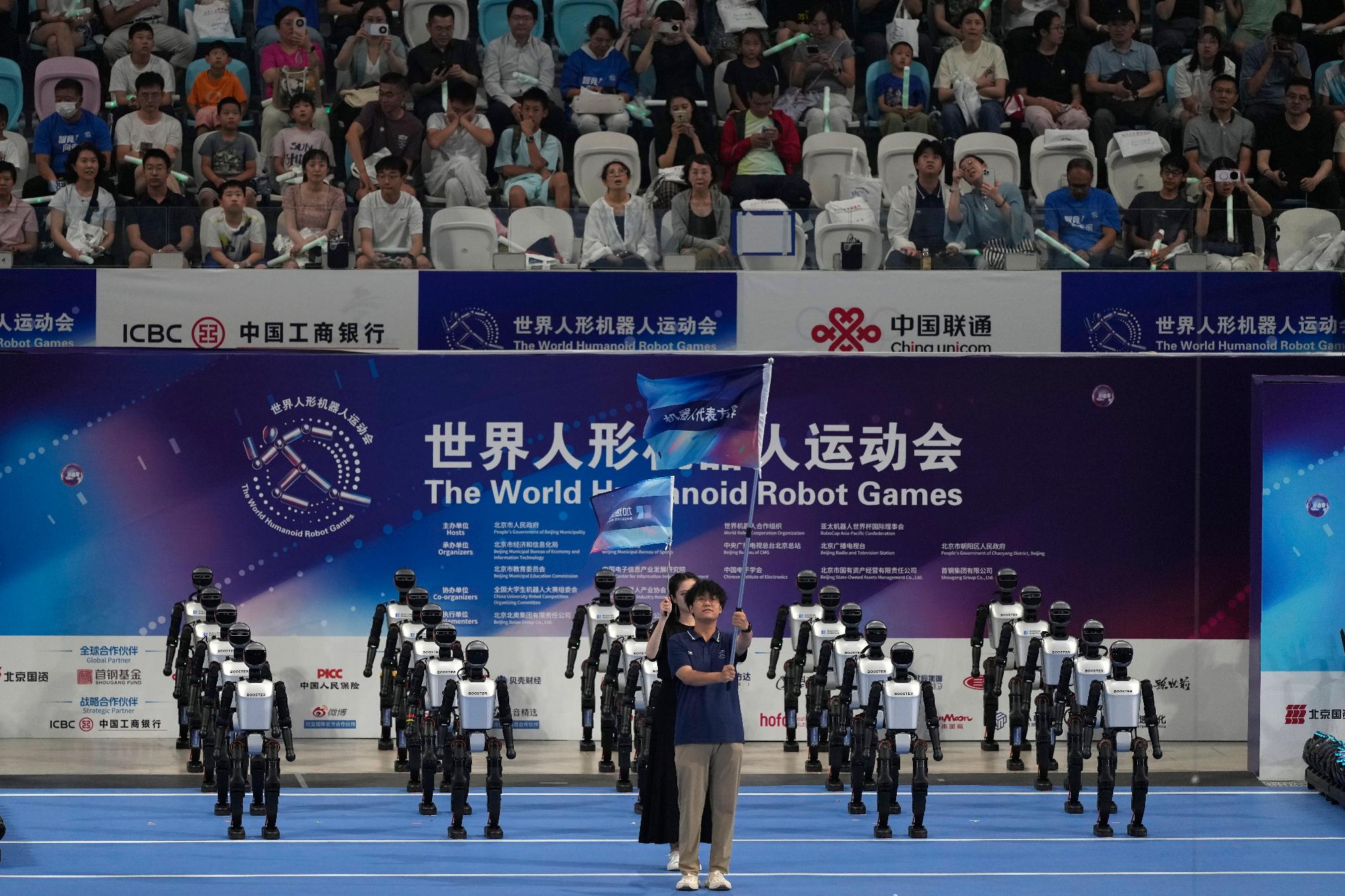 Robots march in for the opening ceremony of The World Humanoid Robot Games held in Beijing, China, Thursday, Aug. 14, 2025. (AP Photo/Ng Han Guan)
