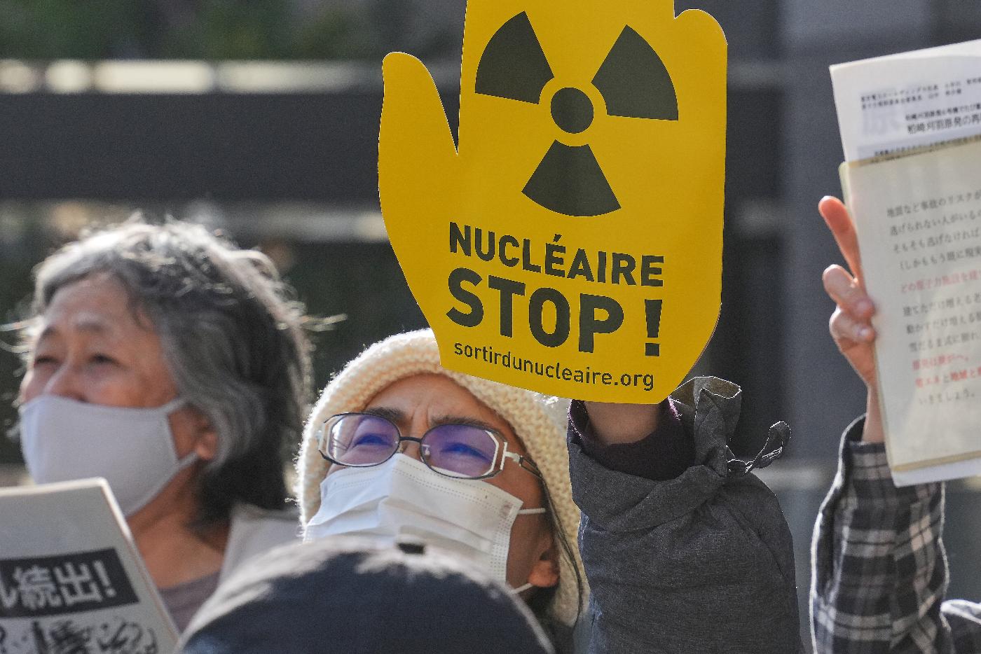 FILE -Protesters hold a sign during a rally against the restart of the No. 6 reactor at the Kashiwazaki-Kariwa nuclear power plant, in front of Tokyo Electric Power Company Holdings (TEPCO) headquarters in Tokyo, Jan. 19, 2026. (AP Photo/Eugene Hoshiko, File)