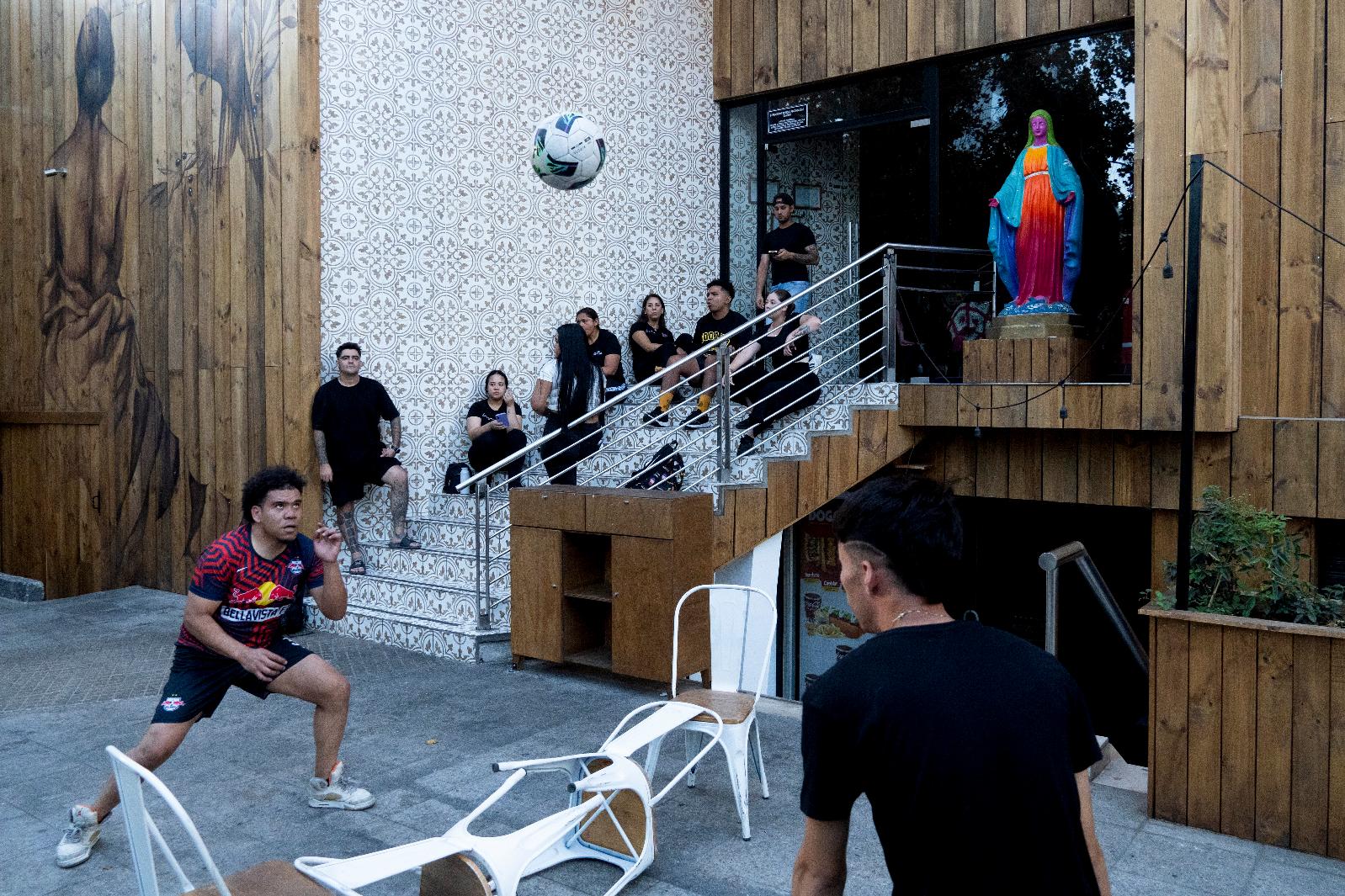 Workers at a bar play with a soccer ball outside their workspace during a power outage in Santiago, Chile, Tuesday, Feb. 25, 2025. (AP Photo/Matias Basualdo)