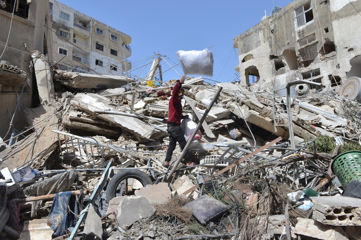 A man collects his family's belongings from the rubble of a building destroyed in an Israeli airstrike the previous day in the southern village of Maarakeh, Lebanon, Sunday, May 17, 2026. (AP Photo/Mustafa Jamalddine)