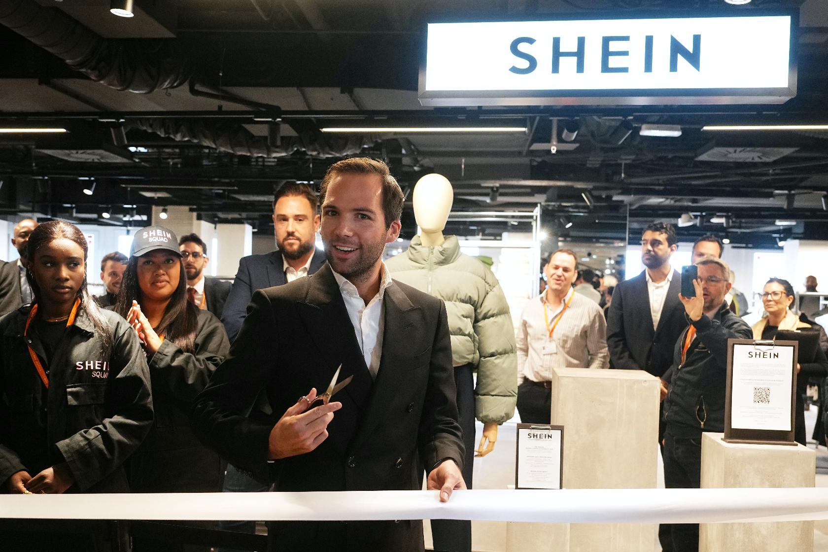 The director of the Bazar de l'Hotel de Ville (BHV) department store Karl-Stephane Cottendin prepares to cut the ribbon at the opening Shein's first physical store in Paris, Wednesday, Nov. 5, 2025. ( Dimitar Dilkoff, Pool via AP)