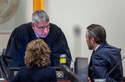 Chief Judge Bryan Biedscheid talks with Linda Singer, an attorney representing the plaintiff, and attorney Kevin Huff, representing Meta, during the closing arguments, Monday, March 23, 2026, in state court, in Santa Fe, N.M., in a trial where the social media conglomerate is accused of misleading its users about how safe its platforms are for children. (Eddie Moore/The Albuquerque Journal via AP, Pool)