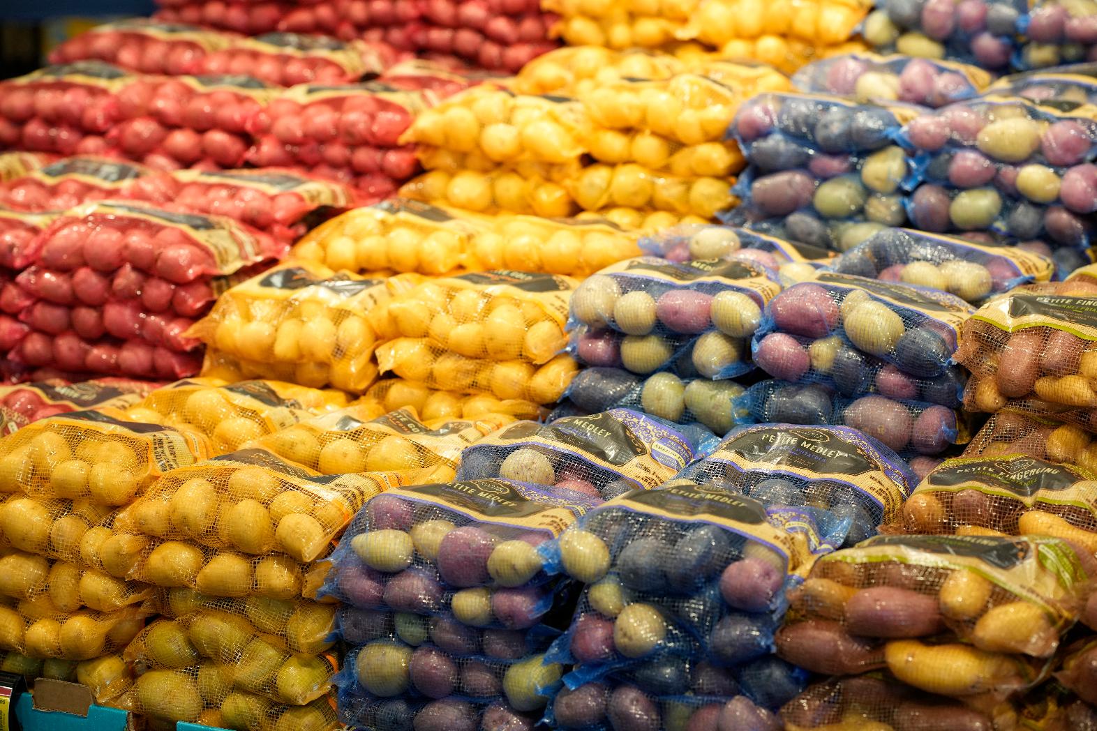 File - Bags of potatoes are displayed in a supermarket Tuesday, Feb. 8, 2022, in Boulder, Colo. Americans are bracing for a costly Thanksgiving this year, with double-digit percent increases in the price of turkey, potatoes, stuffing, canned pumpkin and other staples. (AP Photo/David Zalubowski, File)