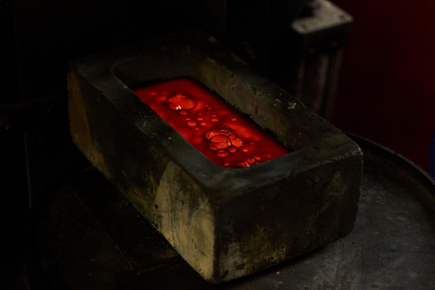 Molten gold settles in a mold at A&M Precious Metals in the St. Vincent Jewelry Center in the Jewelry District of Los Angeles, Friday, May 2, 2025. (AP Photo/Jae C. Hong)