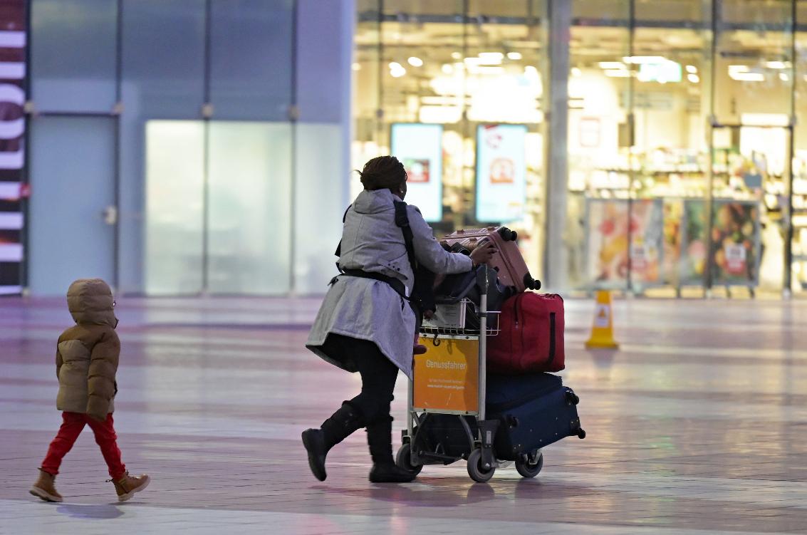 A woman and a child walk through the central area of Munich Airport, Bavaria, Thursday, Feb.12, 2026, as Lufthansa pilots and flight attendants go on a full-day strike. (Malin Wunderlich/dpa via AP)