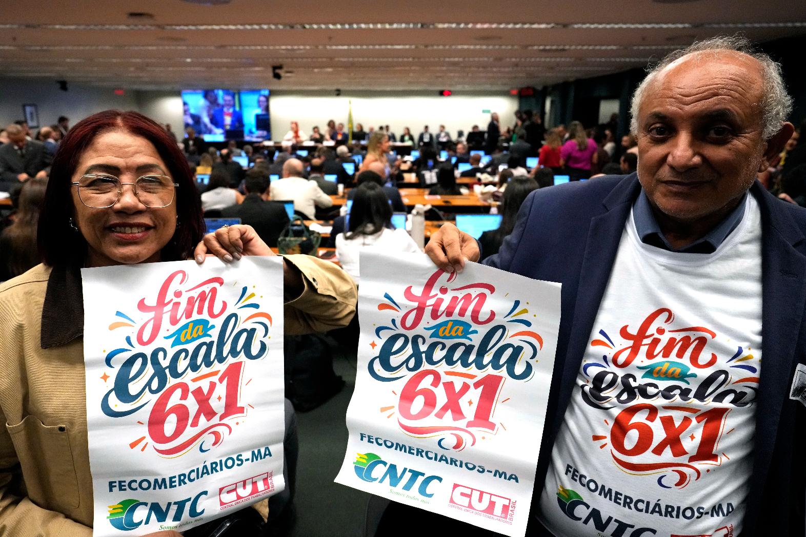 Labor union representatives hold signs calling for the end of Brazil's six-day workweek schedule during a special committee session analyzing the proposal at the Chamber of Deputies in Brasilia, Brazil, Wednesday, May 27, 2026. (AP Photo/Eraldo Peres)