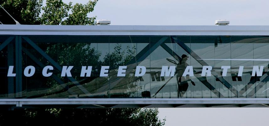 FILE - A man walks past a Lockheed Martin logo as he walks through a section of the company's chalet bridging a road at Farnborough International Airshow in Farnborough, southern England, July 19, 2006. China revealed new details of sanctions it previously announced against two U.S. weapons manufacturers, Lockheed Martin and Raytheon Technologies Corp.’s Raytheon Missiles & Defense, Tuesday, April 18, 2023, including a ban on Chinese companies doing business with them. (AP Photo/Matt Dunham, File)