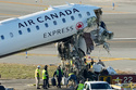 NTSB officials and aircraft maintenance workers pick through debris and remove luggage as they inspect the wreckage of an Air Canada Express jet, Tuesday, March 24, 2026, just off the runway where it had collided with a Port Authority fire truck Sunday night at LaGuardia Airport in New York. (AP Photo/Yuki Iwamura)