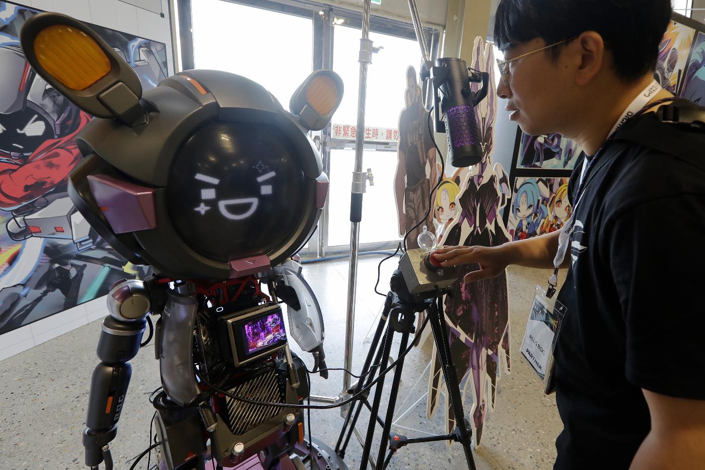 A man communicates with an ASUS Character Virtual Assistant, ROG Omni system during the AI EXPO in Taipei, Taiwan, Wednesday, March 25, 2026. (AP Photo/Chiang Ying-ying)