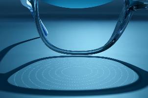 In this photo provided by EssilorLuxottica in October 2025, refractions caused by lenslets embedded in the company's Stellest eyeglass lens are projected onto a table. (Luxottica via AP)