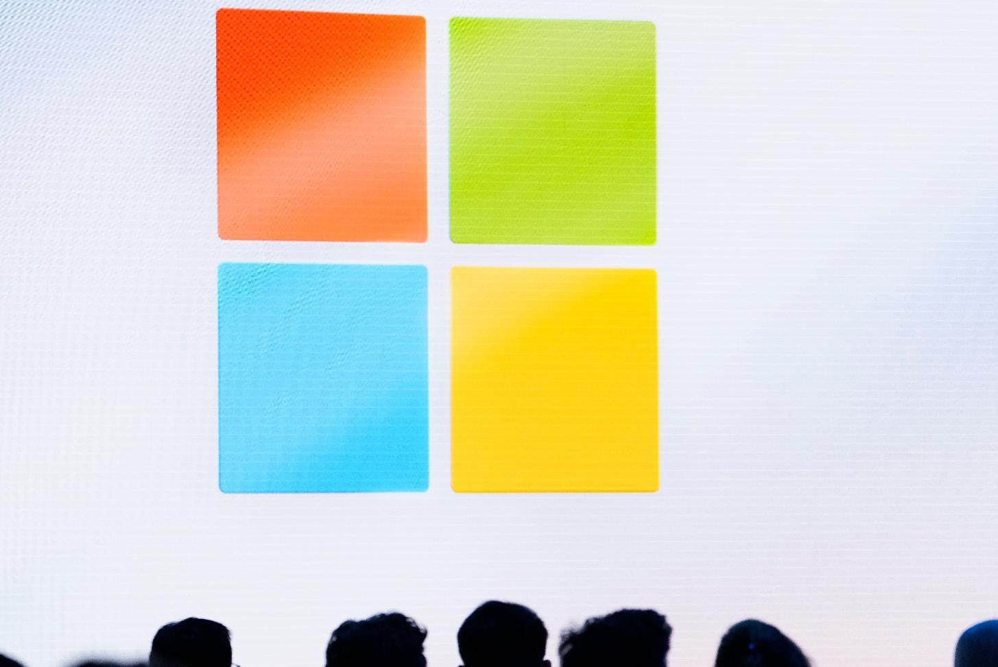 FILE - A Microsoft logo is seen on a screen as people listen at an event at Microsoft headquarters, May 20, 2024, in Redmond, Wash. (AP Photo/Lindsey Wasson, File)