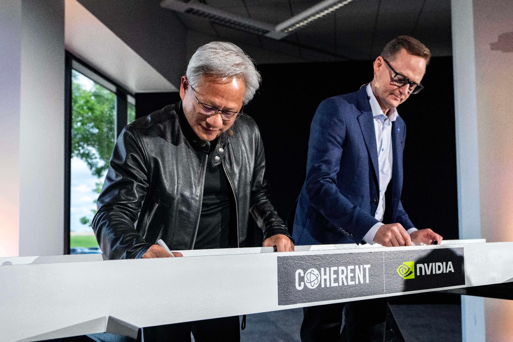 Jensen Huang, left, president and CEO of Nvidia, and Jim Anderson, CEO of Coherent, sign a ceremonial construction beam before a groundbreaking ceremony for an expansion of Coherent's manufacturing facility on Tuesday, June 16, 2026, in Sherman, Texas. (AP Photo/Jeffrey McWhorter)