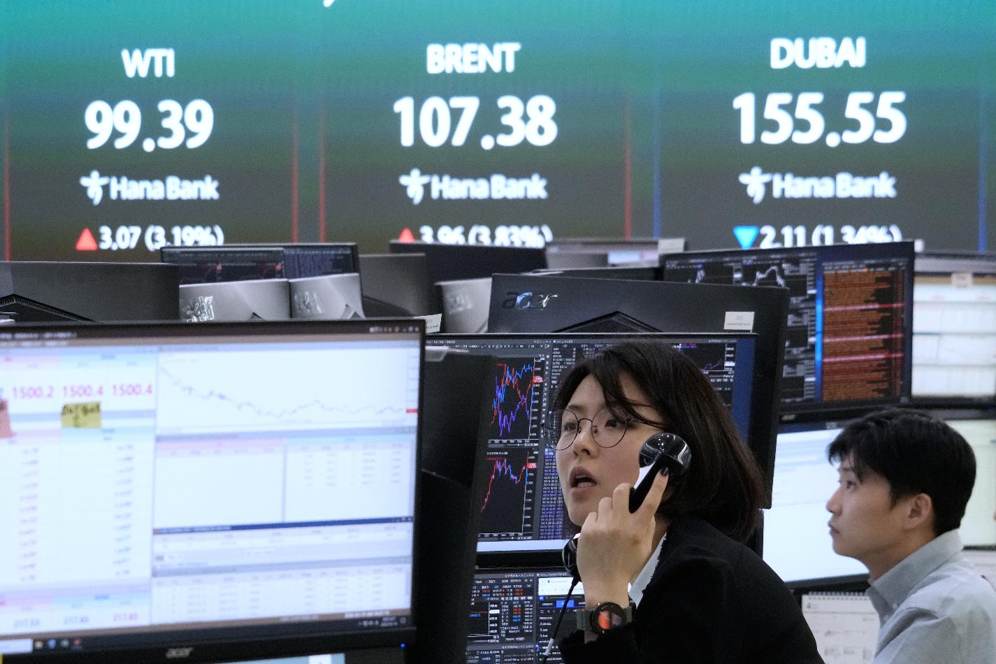 A currency trader works near a screen showing international oil prices at the foreign exchange dealing room of the Hana Bank headquarters in Seoul, South Korea, Thursday, March 19, 2026. (AP Photo/Ahn Young-joon)