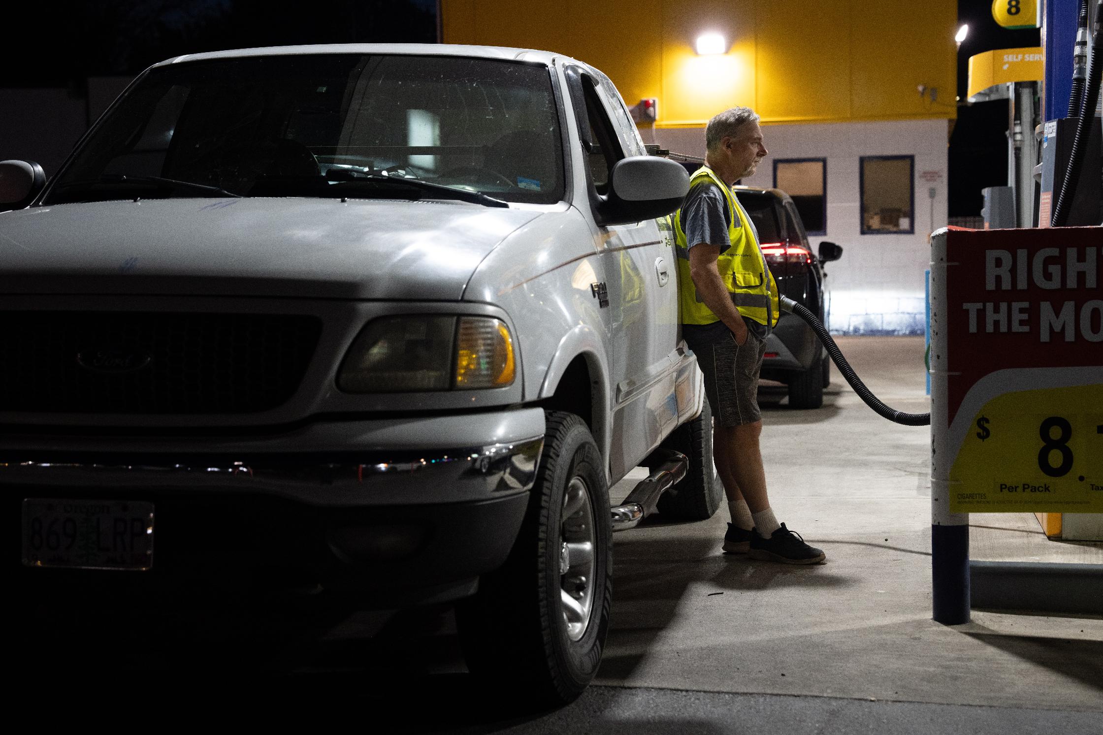 A person waits while filling their fuel tank at an Astro gas station on Wednesday, April 29, 2026, in Portland, Ore. (AP Photo/Jenny Kane)