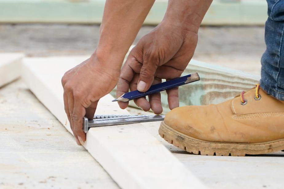 FILE - A workman measures a a piece of wood in Madison County, Miss., on March 16, 2021. Nearly one in three Americans earn money on the side in addition to working full time, a Bankrate survey found. (AP Photo/Rogelio V. Solis, File)