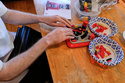 Matthew Shifrin, the founder of Bricks for the Blind, feels for specific pieces while building a LEGO gum ball machine at his family's home, Friday, March 20, 2026, in Newton, Mass. (AP Photo/Charles Krupa)