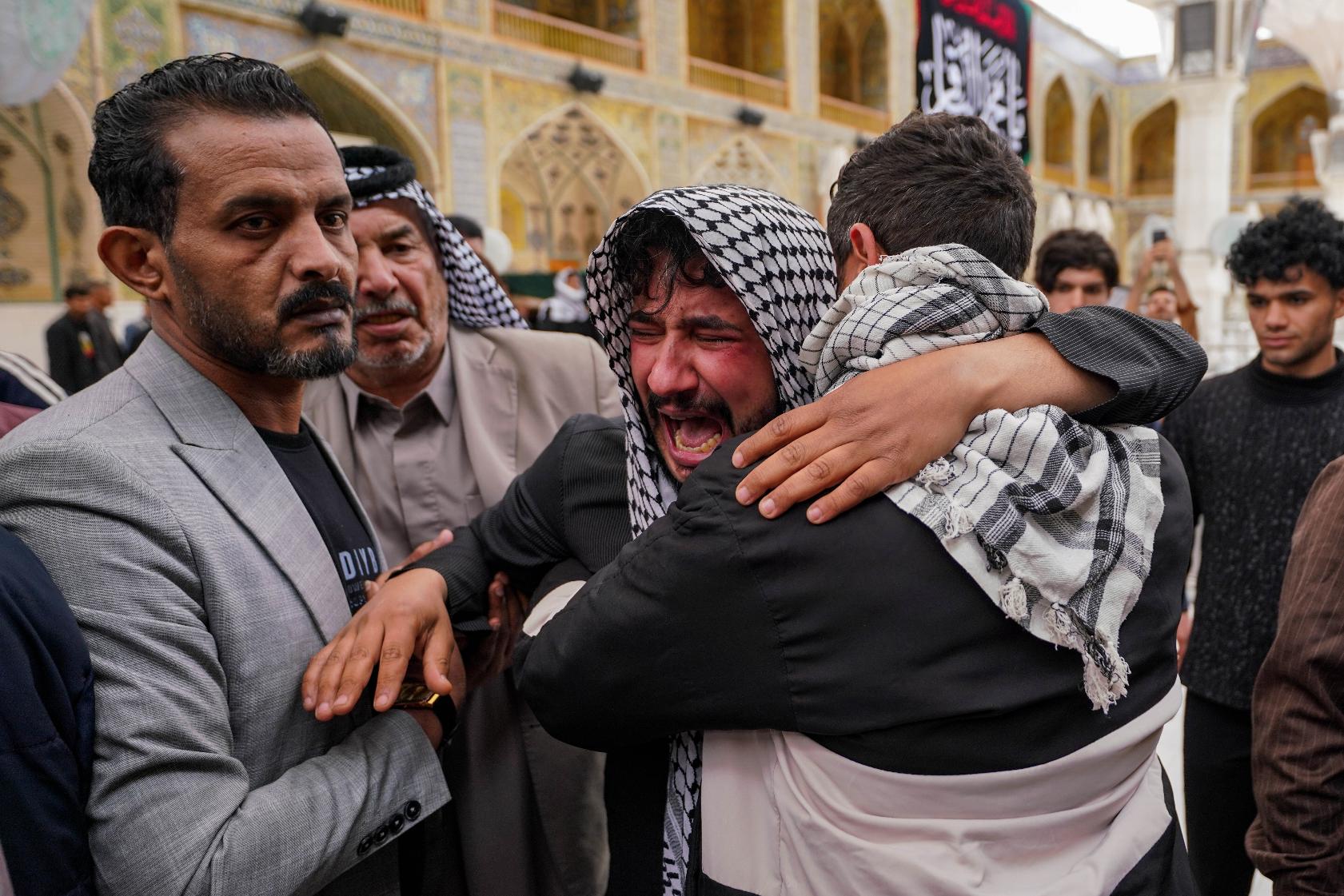 Relatives grieve an Iraqi soldier killed in a strike Wednesday on a military clinic in western Iraq's Anbar province, during a mass procession inside the shrine of Imam Ali in Najaf, Iraq, Thursday, March 26, 2026. (AP Photo/Anmar Khalil)