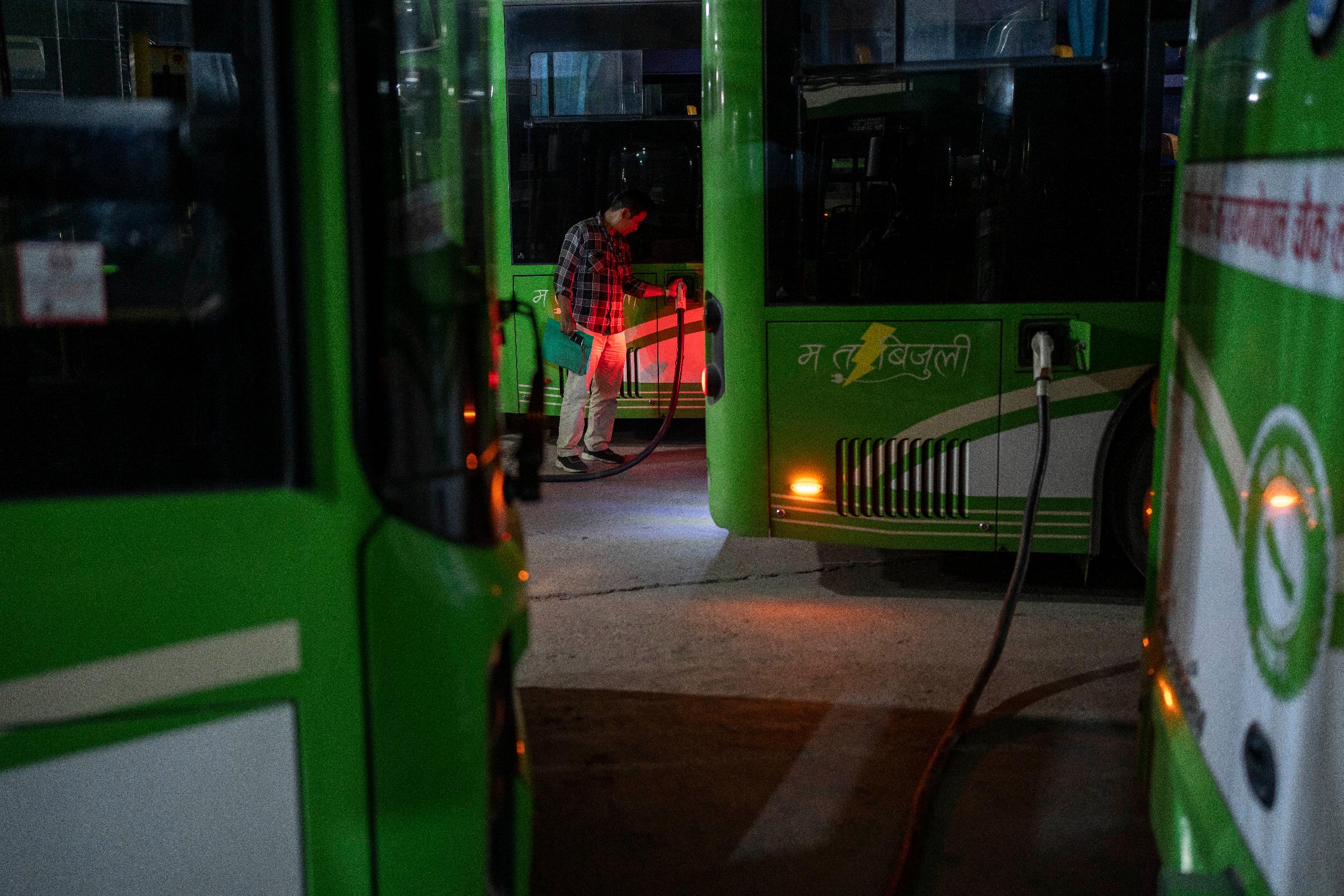 A worker at an electric charging station recharges the batteries of a public transport bus in Kathmandu, Nepal, Friday, May 10, 2024. Nearly all of the electricity produced in Nepal is clean energy, most of it generated by river-fed hydro-electricity. Thanks to that abundant source of power, the country is quickly expanding charging networks and imports of EVs have doubled in each of the past two years, according to customs data. (AP Photo/Niranjan Shrestha)