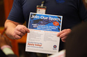 FILE - A recruiter holds information about employment during a hiring fair at Fair Park in Dallas, Jan. 14, 2026. (AP Photo/LM Otero, File)